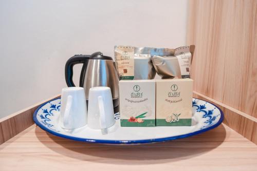 a tray with a tea kettle and packets on a table at DeeProm Pattaya Hotel in Pattaya Central