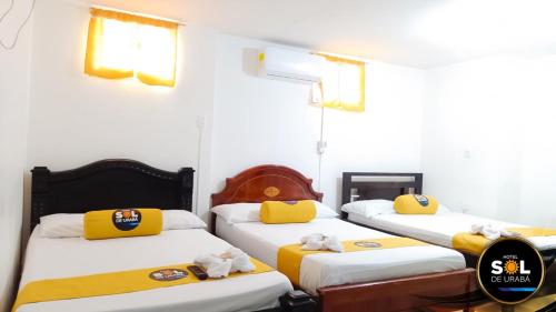 ein Zimmer mit 3 Betten und Handtüchern darauf in der Unterkunft Hotel sol de uraba in Apartadó