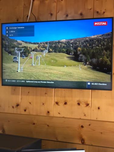 ein TV-Bildschirm, auf dem ein Spiel auf einem Golfplatz gezeigt wird in der Unterkunft Haus Hubertus Pitztal Winterbuchung für Wintersaison oder Sommerbuchung mit Sommercard möglich in Jerzens