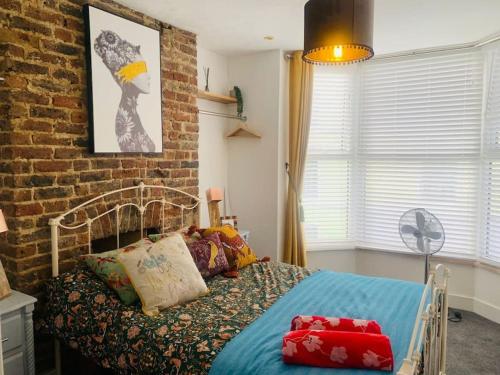a bedroom with a bed and a brick wall at Funky 2 Bedroom Apartment In Town Centre in Hastings