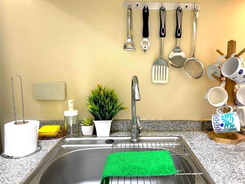a kitchen sink with a green sponge next to it at Paseo Verde Condominium 1 Bedroom for 6 pax in Manila