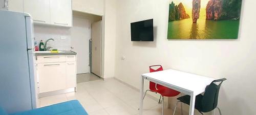 a kitchen with a white table and red chairs at Beachfront Studio Apartment Bat Yam 412 in Bat Yam