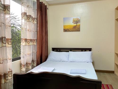 a bedroom with a bed and a window with a tree at Paseo Verde Condominium 1 Bedroom for 6 pax in Manila