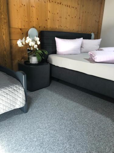 a bedroom with two beds and a vase with flowers at Haus Hubertus Sommerpreise incl Sommercard in Jerzens