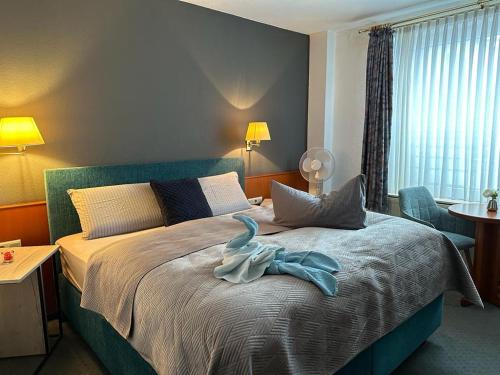 a bedroom with a bed with a blue bird on it at Hotel Oberledinger Hof in Leer