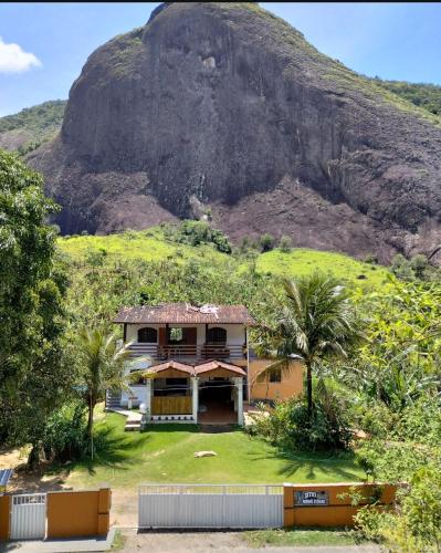 a house in front of a mountain at Pousada Moinho D'água in Guarapari