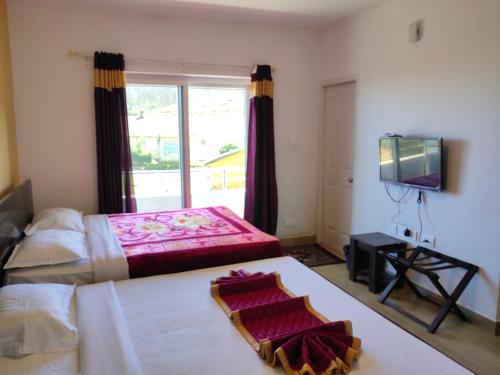 a bedroom with a large bed and a television at Forest Gate in Ooty