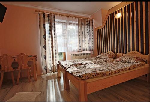 a bedroom with a large bed and a window at Dom Wczasowy Salamon in Poronin