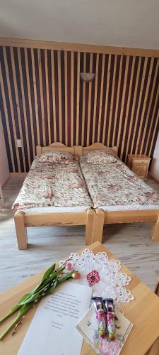 a bed with a table with flowers and glasses on it at Dom Wczasowy Salamon in Poronin