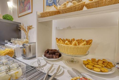 a table with plates of pastries and a basket of bread at Vila Camacho Guest House in Funchal