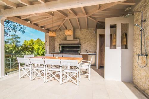 una cocina al aire libre con mesa y sillas en un patio en My Mediterranean Corfu Luxury Villa with Private Swimming Pool en Kontokali