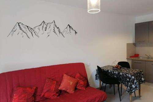 uma sala de estar com um sofá vermelho e uma mesa em Gîtes chez Sylvie em Arreau