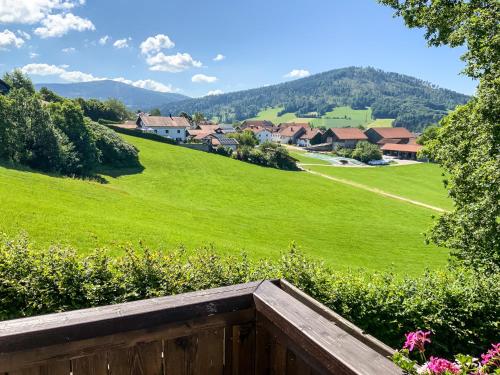 vistas a un campo verde con casas en una colina en Ferienwohnung Freudensee im Bayerischen Wald - Pool, Sauna, en Hauzenberg