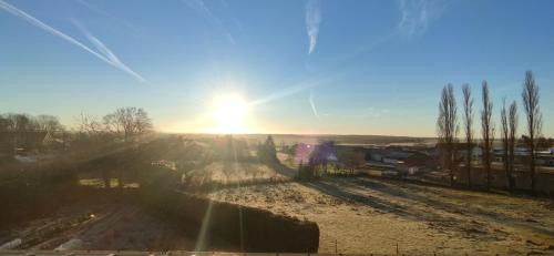 una imagen de la puesta de sol sobre un campo en Le Relais de La Poste 2, en Colombey-les-deux-Églises