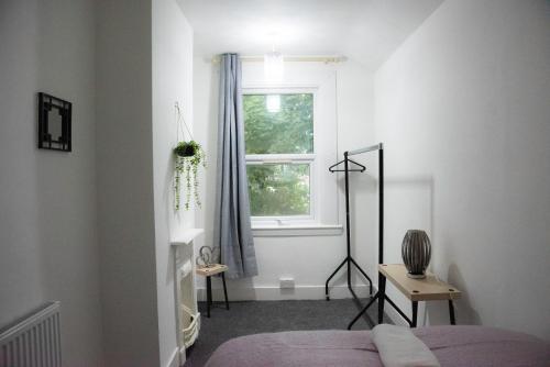 a bedroom with a bed and a window at Coral Place in Luton