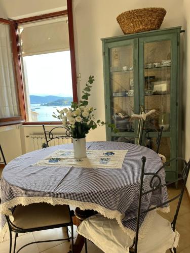 Una mesa de comedor con un jarrón de flores encima. en Vittoria 19, en Portovenere