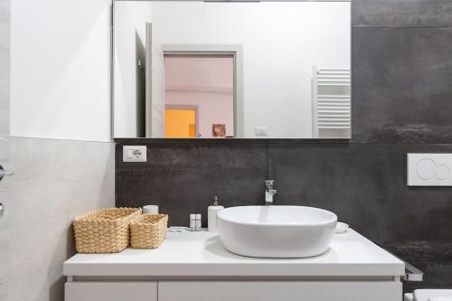 een badkamer met een witte wastafel en een spiegel bij Modern Apartment near Ponte Vecchio. in Florence