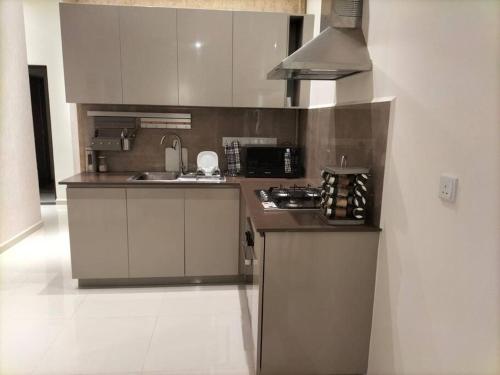 a kitchen with a sink and a stove top oven at Apartment with Pool & Gym in Colombo