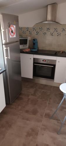 Il comprend une cuisine équipée d'un réfrigérateur en acier inoxydable et d'une cuisinière. dans l'établissement Logement T2 Indépendant meublé RDC, à Saint-Avit-Saint-Nazaire