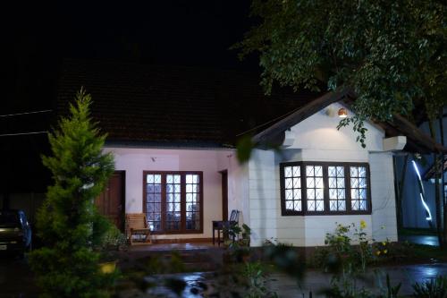 a small white house with windows at night at Carpe DiemStay in Kushālnagar