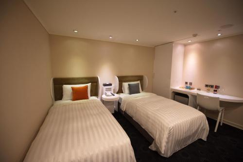 a hotel room with two beds and two nightstands at Ximen Airline Hotel in Taipei