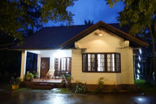 a small white house with a porch at night at Carpe DiemStay in Kushālnagar