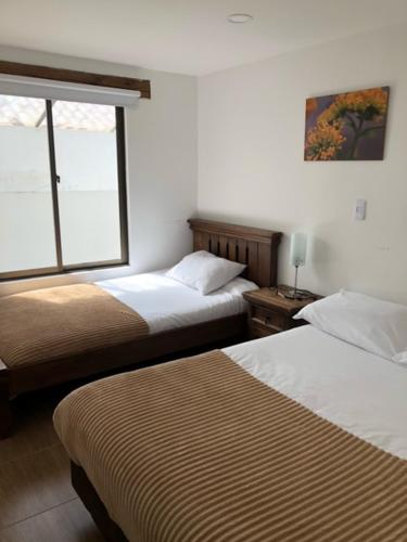 Habitación de hotel con 2 camas y ventana en Hacienda Moncora, un lugar hermoso para toda la familia y los amigos, en El Rosal