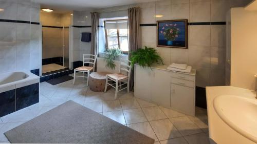 La salle de bains est pourvue d'une baignoire, d'un lavabo et de toilettes. dans l'établissement 103 m2 Apartment EschenWald vomLandl Leogang, à Leogang