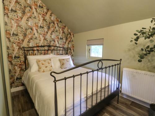 ein Schlafzimmer mit einem Bett und einer Wand mit einem Wandbild in der Unterkunft Pheasant in Carthorpe