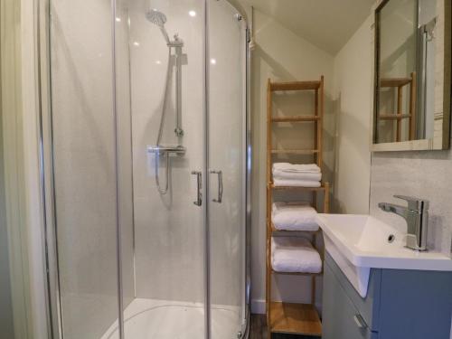 ein Bad mit einer Dusche und einem Waschbecken in der Unterkunft Pheasant in Carthorpe