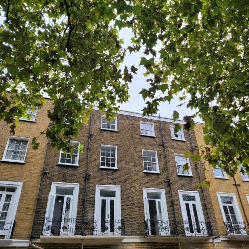 een groot gebouw van rode baksteen met witte ramen bij Argyle Square Hotel in Londen