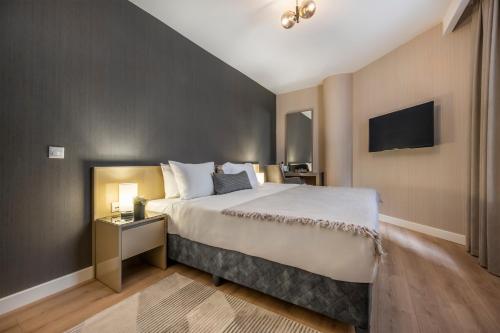 um quarto de hotel com uma cama grande e uma televisão em SVK Bosphorus Residence em Istambul