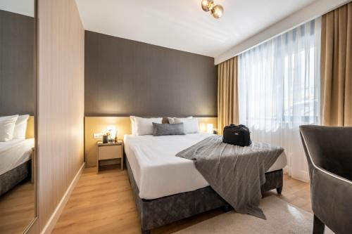 ein Hotelzimmer mit einem Bett und einem Stuhl in der Unterkunft SVK Bosphorus Residence in Istanbul