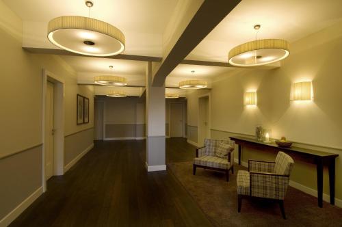 a hallway with chairs and a table and lights at Historisches Alpinhotel Grimsel Hospiz in Grimsel Hospiz