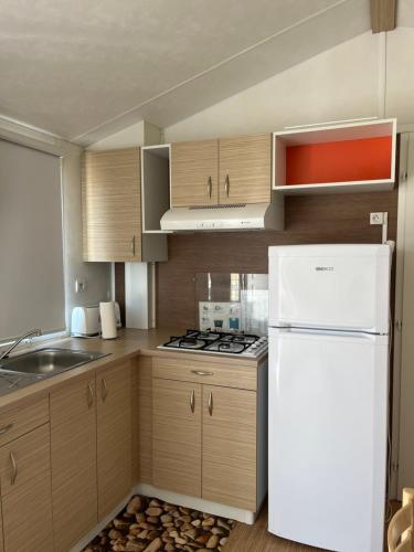 eine Küche mit Holzschränken und einem weißen Kühlschrank in der Unterkunft Hospedaria O Castelo in Portel