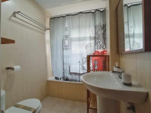 een badkamer met een wastafel en een raam met een klokkentoren bij Estudio venus in Sierra Nevada