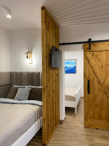 a bedroom with a bed and a sliding barn door at Apartament La Playa! Najlepsza lokalizacja! in Hel