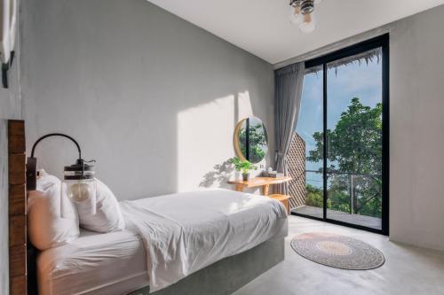 ein Schlafzimmer mit einem Bett und einem großen Fenster in der Unterkunft Vikasa Yoga Retreat in Koh Samui 