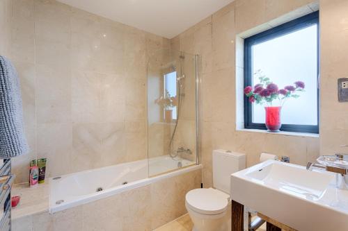 a bathroom with a tub and a toilet and a sink at Beach Lodge in Barna