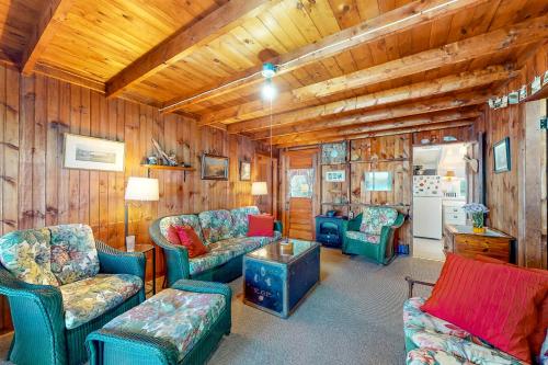 Alton BayにあるLake Winnipesaukee's Charmerの木製の壁と椅子、テーブルが備わるリビングルーム