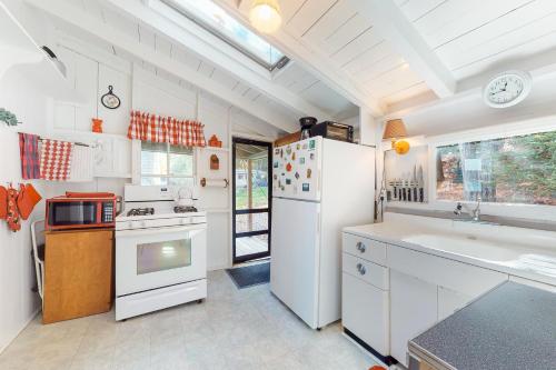 Alton BayにあるLake Winnipesaukee's Charmerの白い冷蔵庫とシンクのあるキッチン