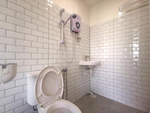 La salle de bains blanche est pourvue de toilettes et d'un lavabo. dans l'établissement Maco Inn Century @Johor Bahru, à Johor Bahru