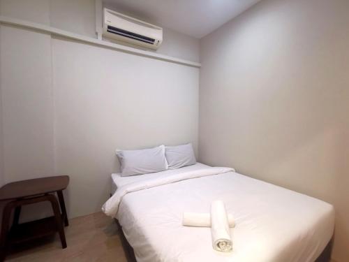 ein Schlafzimmer mit einem Bett mit zwei Handtüchern darauf in der Unterkunft Maco Inn Century @Johor Bahru in Johor Bahru