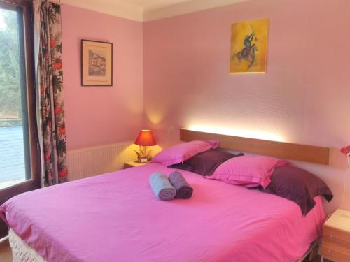 a pink bedroom with a large bed with pink sheets at Bed & Diner Les Terrasses de La Palme in Lapalme