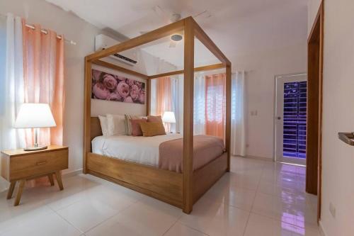 a bedroom with a canopy bed in a room at Villa Escondida #3 In the center of POP city in San Felipe de Puerto Plata