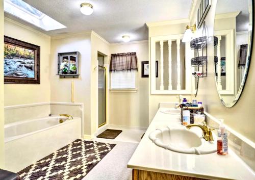 a bathroom with a sink and a bath tub and a sink at Comfortable and Pleasant 4 Bedroom Home in Memphis