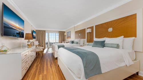 a hotel room with two beds and a television at La Mer Beachfront Resort in Cape May