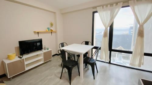 a living room with a table and chairs and a television at Amanecer del Fuego III in Ushuaia