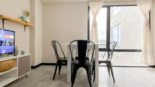 a dining room with a table and chairs and a television at Amanecer del Fuego III in Ushuaia
