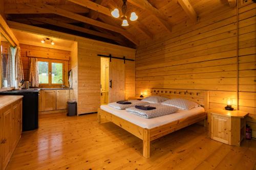 a bedroom with a bed in a wooden cabin at Vyhlídkový srub na kraji Brd in Hŭrky